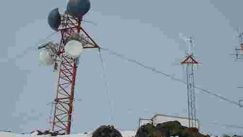 Funkstation mit Antennen und Windgenerator im Winter
