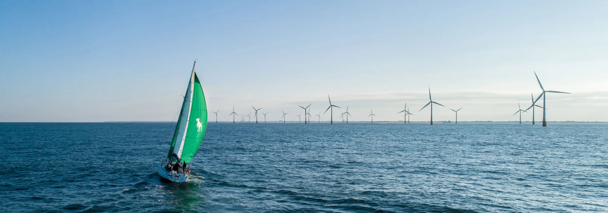 Segelboot auf offener See vor einem Windpark