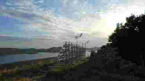 Landschaftsbild mit Mobilfunksendeanlage mit Photovoltaik und Windkraftanlage Superwind SW 1250